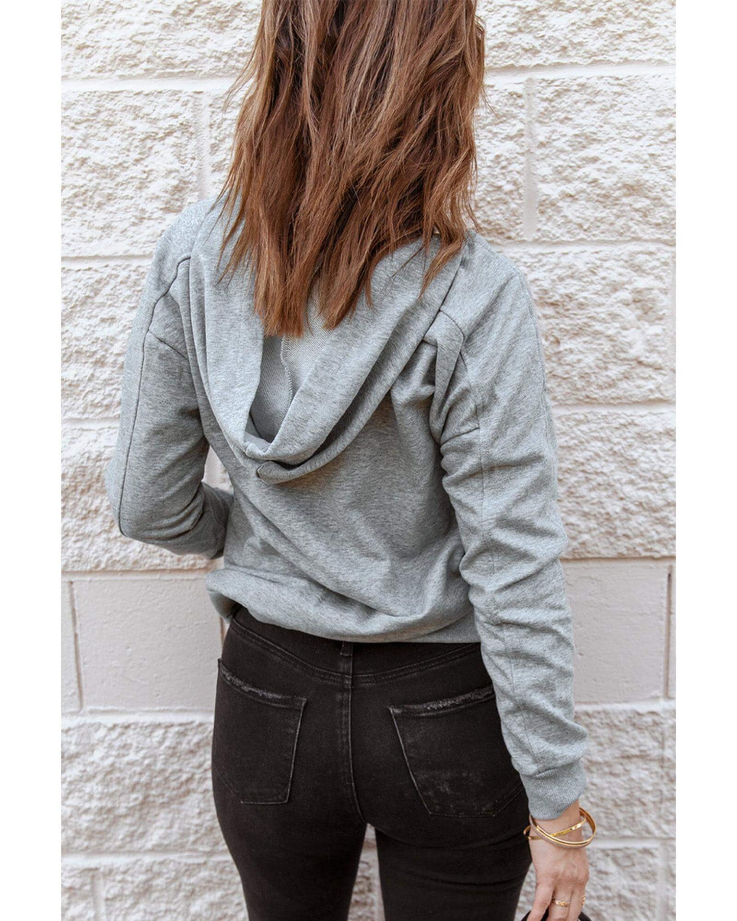 Back view of a woman in a grey lace-up casual hoodie, showcasing a trendy and comfortable style from Layna.com.au.