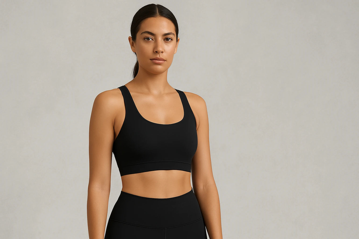 Stylish woman in a black sports bra and leggings, showcasing athletic wear for workouts and yoga.