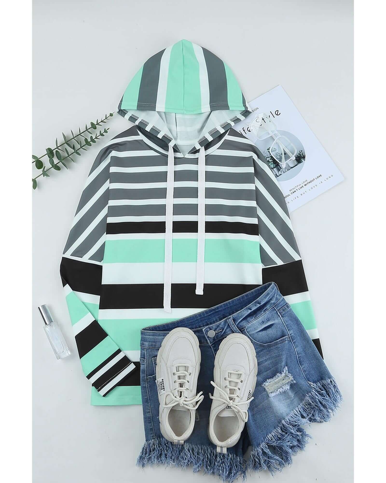 Stylish women's casual hoodie featuring a striped pattern, paired with denim shorts and sneakers for a laid-back look.