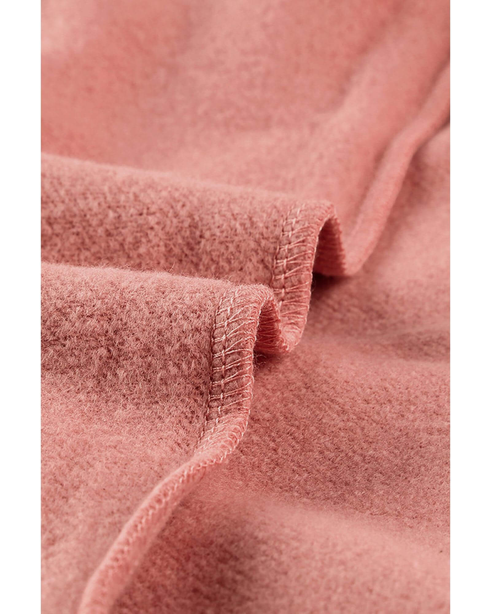 Close-up of the soft pink fabric of a women's casual hoodie, showcasing its cozy texture.