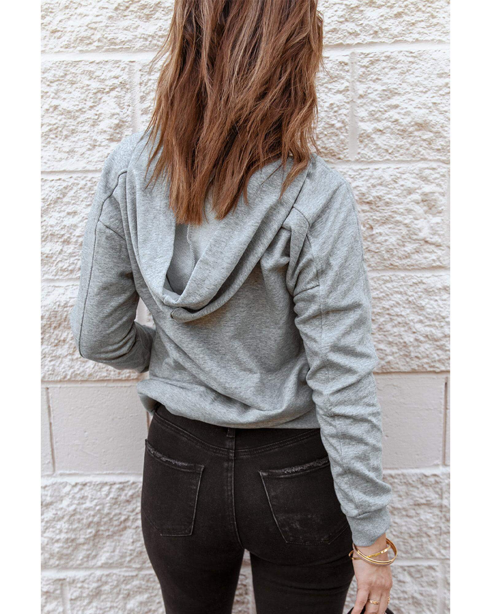 Back view of a woman in a grey lace-up casual hoodie, showcasing a trendy and comfortable style from Layna.com.au.