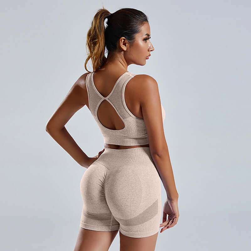 Women's activewear set featuring a seamless sports vest and high-waist shorts in a light beige hue.