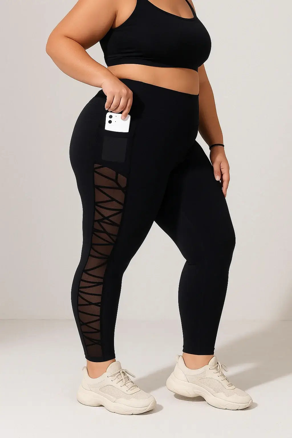 Black Plus Size Compression Leggings – Mesh, Sculpting Fit worn by a curvy woman with a phone in her pocket.
